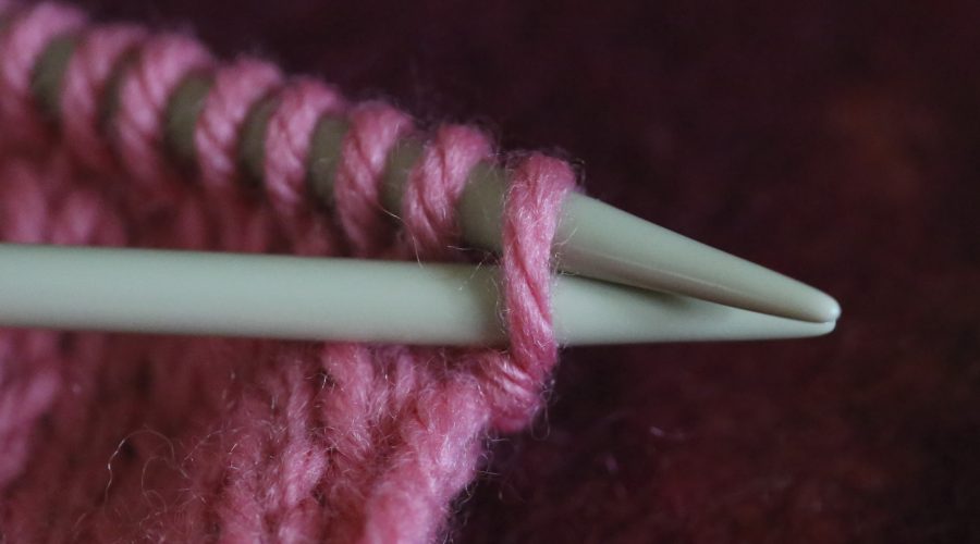 Knitting needles and pink yarn. Looks like the start of something fun!