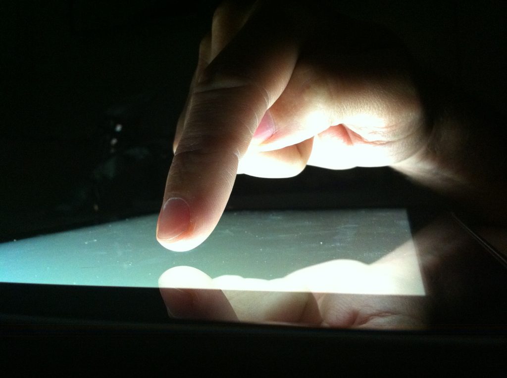 Finger aaaaaaalmost touching a glowing-white device screen. Is that…that right there…is that the future?