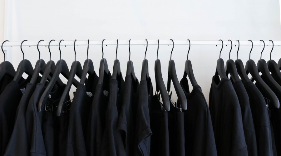 A row of pretty much identical black clothes hangs on a a rod. Gosh, which one should I pick this time?
