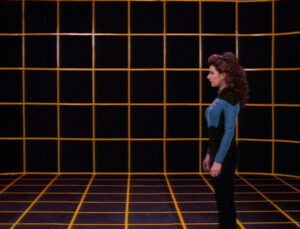 Star Trek character stands alone on the yellow grid of an empty holodeck