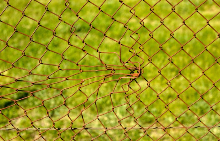 A chain-link fence has been damaged through forceful impact. Hyperlinks, too, provide shape and surface to texts, and they also have expected patterns to follow.